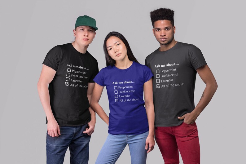 May include: Three people wearing black and blue t-shirts with the text "Ask me about..." and a checklist of options. The options include Peppermint, Frankincense, Lavender, and All of the above. One person wears a green cap.