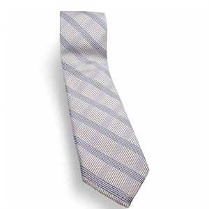 May include: A light-colored tie with a striped pattern. The tie features alternating stripes of light gray, tan, and navy blue. The tie is angled diagonally against a white background.