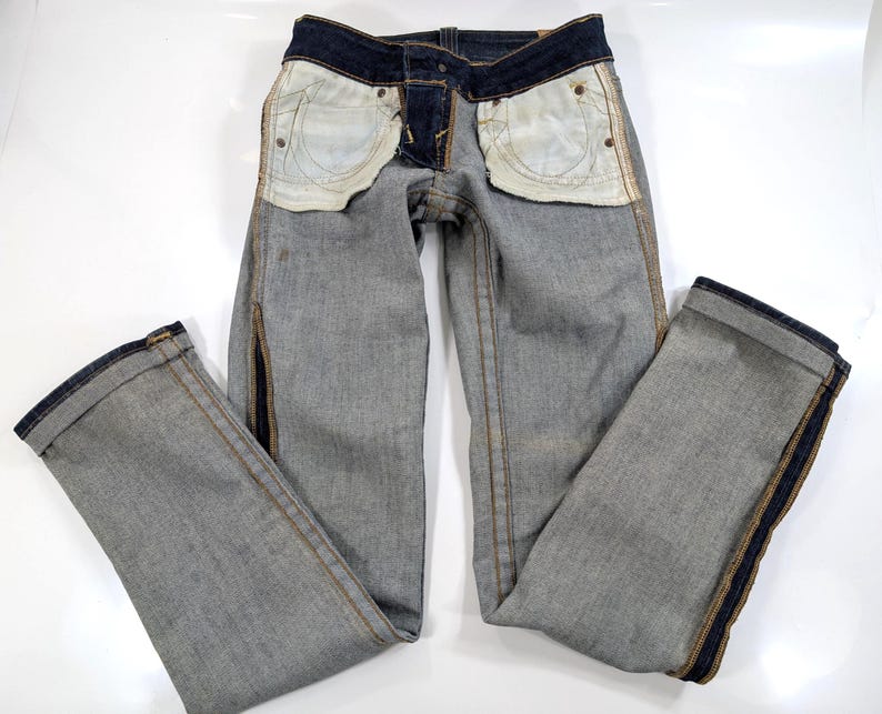 Pode incluir: Cal&ccedil;as de ganga azul claro com detalhes em azul escuro na cintura e nas costuras laterais. As cal&ccedil;as de ganga t&ecirc;m um design cl&aacute;ssico de cinco bolsos e um corte reto. Os bolsos interiores s&atilde;o de cor bege claro.