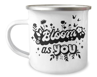 May include: White enamel mug with a black design of flowers and the text "Bloom as you".