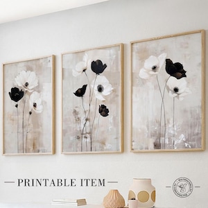 May include: Set of three abstract floral prints featuring black and white flowers on a beige background. The prints are framed in a light wood frame.