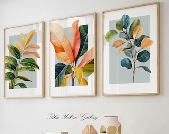 May include: Three framed botanical prints with a light blue background. The prints feature stylized illustrations of green, yellow, orange, and red leaves.