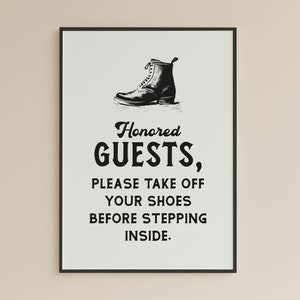 May include: Black and white sign with a boot illustration and the text "Honored Guests, Please take off your shoes before stepping inside."