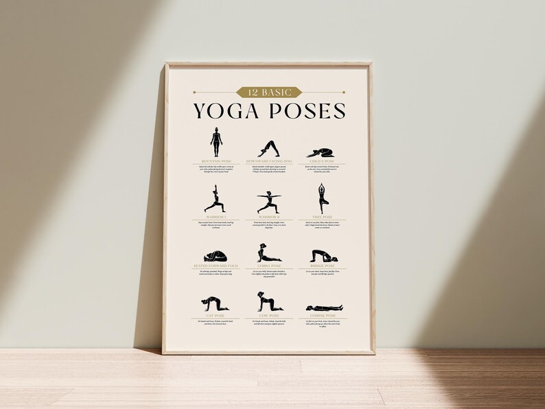 May include: A framed poster displaying 12 basic yoga poses in black silhouettes against a cream background. The title "12 Basic Yoga Poses" is in gold lettering. The poster is leaning against a wall on a wooden floor.