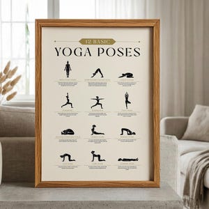 May include: A framed print featuring 12 basic yoga poses in black silhouettes on a cream background. The print is in a light brown wooden frame and includes the text "12 Basic Yoga Poses" at the top.