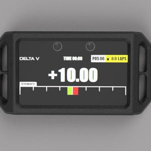 Może przedstawiać: Czarny prostokątny wyświetlacz cyfrowy z napisem "DELTA V" i "+10.00". Wyświetlacz pokazuje "TIME 00:00", "POS 00" i "0.0 LAPS". Wyświetlacz ma czarną ramkę z dwoma okrągłymi elementami na górze.