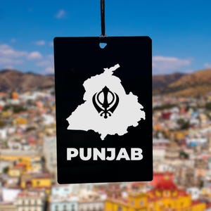 May include: Black and white car air freshener with a white outline of the state of Punjab, India, and a black Khanda symbol in the center. The text "PUNJAB" is printed in white below the state outline.