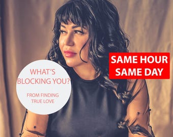 May include: A woman with dark curly hair looks to the right of the frame. She is wearing a black top with a sheer overlay. The text "What's Blocking You? From Finding True Love" is in a white circle. The text "Same Hour Same Day" is in a red rectangle.