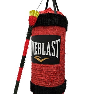 Peut inclure: Une piñata cylindrique rouge et noire en forme de sac de frappe avec une sangle noire sur le dessus. Le centre présente une étiquette rectangulaire noire avec le texte blanc EVERLAST et un logo doré. Un bâton assorti rouge et noir est inclus.