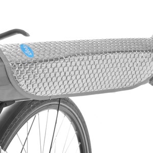 Puede incluir: Un protector de calor plateado con patrón de panal para una batería de bicicleta eléctrica. El protector se fija al cuadro de la bicicleta con velcro.