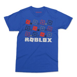 May include: A royal blue t-shirt with a white "ROBLOX" logo and a pattern of red, black, and gray squares.