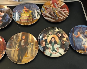 May include: A collection of decorative plates featuring scenes and characters from a classic novel. The plates showcase detailed illustrations with vibrant colors, depicting various moments from the story. The plates are round and have a glossy finish.