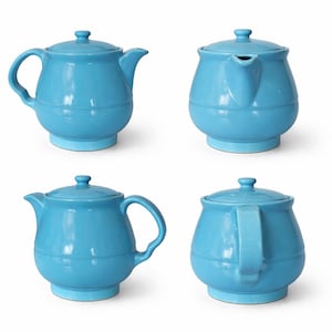 May include: Four views of a light blue ceramic teapot with a lid, spout, and handle. The teapot has a rounded body and sits on a small base. The handle is curved, and the spout is angled. The lid has a small knob.