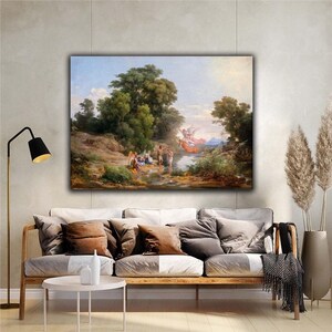 May include: A framed canvas print of a classical landscape painting. The artwork depicts figures near a body of water, with lush green trees and a bright sky. The painting is displayed above a sofa with throw pillows.