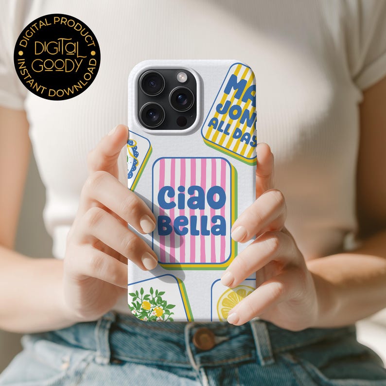 May include: White phone case with a colorful design featuring the words "Ciao Bella" in blue and pink, along with other text and illustrations. The case has a glossy finish and is held by a person.