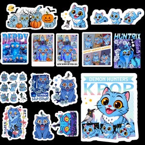 May include: A collection of blue cat-themed stickers with various designs. Some stickers feature cats with pumpkins, bats, and moons, while others have text like "DERPY" and "KPOP DEMON HUNTERS." The stickers are colorful and cartoonish.