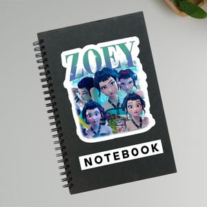 May include: Black spiral-bound notebook with a sticker featuring the word "ZOEY" in teal and blue, and an illustration of several animated characters. The word "NOTEBOOK" is printed in white on a black rectangle.