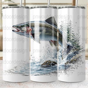 May include: A white tumbler featuring a detailed illustration of a jumping fish with water splashes and a forest background. The fish is gray, red, and silver, with a detailed design. The tumbler has a silver straw.