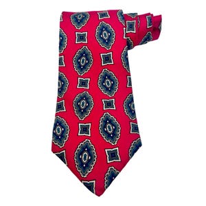 May include: A red necktie with a repeating pattern of blue, white, and green paisley-like designs. The tie is made of a smooth fabric and is knotted at the top, showcasing the intricate pattern.