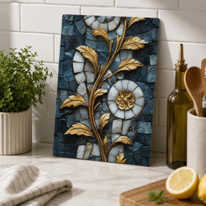 Peut inclure: Une planche à découper rectangulaire en verre présentant un motif de style mosaïque composé de carreaux bleu foncé et blancs. Un relief doré représentant une tige centrale avec des feuilles et une fleur circulaire recouvre le motif.