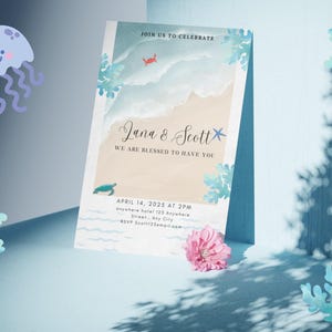 May include: A wedding invitation with a beach theme. The invitation features the names "Jana & Scott" and the text "We are blessed to have you." The date and time are April 14, 2025, at 2 PM. The invitation is decorated with sea creatures and floral accents.