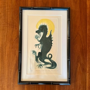 May include: A framed print featuring a dark green dragon illustration with a yellow circular halo behind its head. The artwork is titled "Twas Brillig and the Slithy Toves" by Fancy Favez, numbered 46/250, and enclosed in a black bamboo-style frame.