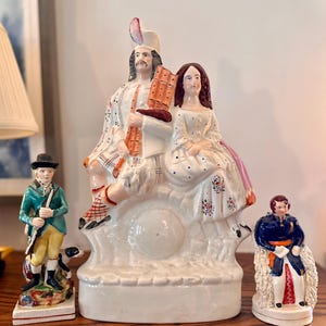 Antiga estatueta vitoriana de Staffordshire representando um casal das Terras Altas da Escócia.