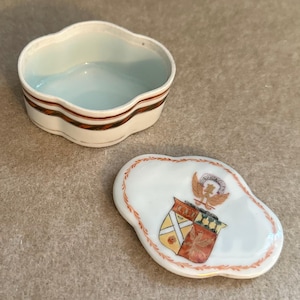 May include: A set of three ceramic mugs with a speckled, matte finish. Each mug features a different color: light blue, cream, and gray. The mugs have a simple, modern design with a rounded shape and a comfortable handle.