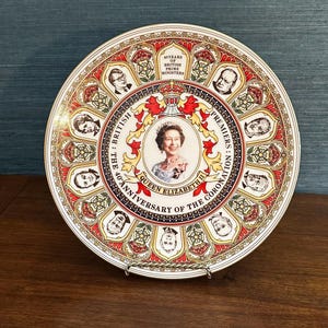 Könnte beinhalten: Ein dekorativer Keramikteller mit einem zentralen Porträt von Königin Elizabeth II., umgeben von Porträts britischer Premierminister. Der Text lautet 40 YEARS OF BRITISH PRIME MINISTERS und THE 40TH ANNIVERSARY OF THE CORONATION OF QUEEN ELIZABETH II.