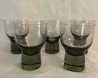 Peut inclure: Ensemble de six verres à pied en verre gris avec une base large et un bol arrondi. Les verres sont transparents et ont une teinte gris fumée.