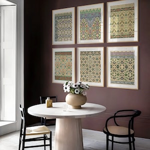 Peut inclure: Six impressions encadr&eacute;es de motifs g&eacute;om&eacute;triques complexes dans des tons de vert, bleu et rouge, accroch&eacute;es &agrave; un mur bordeaux. Les impressions sont dispos&eacute;es en deux rang&eacute;es de trois, avec une table ronde blanche et des chaises noires au premier plan.