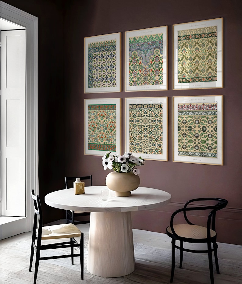 Peut inclure: Six impressions encadr&eacute;es de motifs g&eacute;om&eacute;triques complexes dans des tons de vert, bleu et rouge, accroch&eacute;es &agrave; un mur bordeaux. Les impressions sont dispos&eacute;es en deux rang&eacute;es de trois, avec une table ronde blanche et des chaises noires au premier plan.