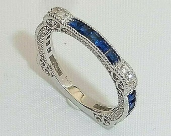 May include: A silver band ring with a row of blue sapphires and small diamonds set in a filigree design.