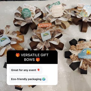 May include: Several decorative gift bows with brown, tan, and black ribbons. Each bow features a small sign with outdoor-themed text like "Nature," "Forest," and "Let's Go Camping." The bows are arranged on a white surface.