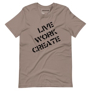 Könnte beinhalten: Ein hellbraunes T-Shirt mit dem Aufdruck "LIVE WORK CREATE" in Schwarz auf der Vorderseite.