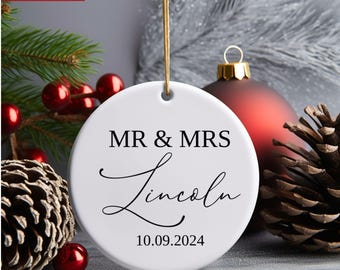 Könnte beinhalten: Weißer Keramik-Weihnachtsbaumschmuck mit schwarzem Text "MR & MRS Lincoln 10.09.2024".