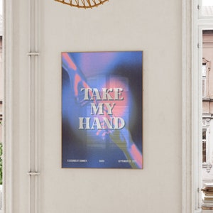 May include: A blue and pink poster with the text "TAKE MY HAND" in white letters. The poster has a blurry image of two hands reaching towards each other. The text "6 SECONDS OF SUMMER" is at the bottom left corner of the poster, and the text "SEPTEMBER 22, 2023" is at the bottom right corner.