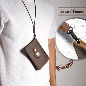 May include: A brown leather phone case with a lanyard attached. The case has a circular cutout on the back. The lanyard is connected to the case with a metal clasp. "Lanyard Connecting" is written on the image.