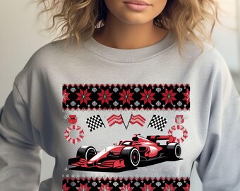 May include: A light gray sweatshirt featuring a red Formula 1 race car design. The design includes checkered flags, a wreath, and a festive pattern in red and black, creating a holiday theme.