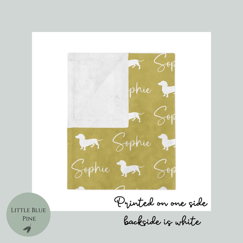Peut inclure: Couverture moutarde avec un motif r&eacute;p&eacute;t&eacute; de silhouettes de teckels blancs et le nom "Sophie" en cursive. La couverture est imprim&eacute;e sur une face, le verso est blanc.