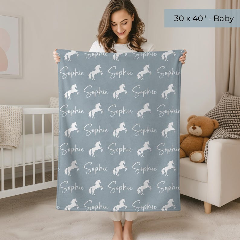 Pu&ograve; includere: Una coperta per bambini, di 76 x 102 cm, in una tonalit&agrave; blu tenue. La coperta presenta un motivo ripetuto di cavalli bianchi che si impennano e il nome "Sophie" in corsivo. La coperta &egrave; progettata per un bambino.