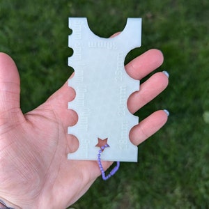 Peut inclure: Jauge en plastique blanc avec une d&eacute;coupe en forme d'&eacute;toile et une cha&icirc;ne violette attach&eacute;e. La jauge est gradu&eacute;e en 5 mm, 8 mm, 10 mm, 12 mm, 15 mm, 20 mm et 25 mm.