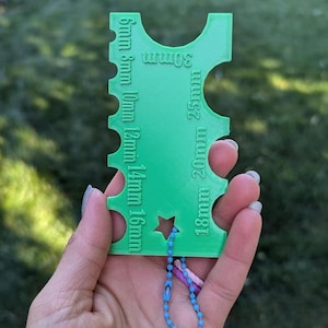 Peut inclure: Outil porte-cl&eacute;s en plastique vert avec une d&eacute;coupe en forme d'&eacute;toile et une cha&icirc;ne bleue. L'outil comporte des mesures en millim&egrave;tres&nbsp;: 6&nbsp;mm, 8&nbsp;mm, 10&nbsp;mm, 12&nbsp;mm, 14&nbsp;mm, 16&nbsp;mm, 18&nbsp;mm, 20&nbsp;mm, 25&nbsp;mm, 30&nbsp;mm.