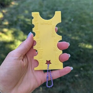 Peut inclure: Jauge en plastique jaune avec une &eacute;toile et une cha&icirc;ne violette. La jauge comporte des mesures en millim&egrave;tres de 5 mm &agrave; 30 mm.