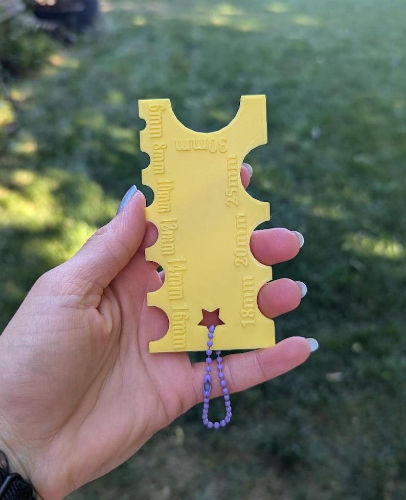 Peut inclure: Jauge en plastique jaune avec une &eacute;toile et une cha&icirc;ne violette. La jauge comporte des mesures en millim&egrave;tres de 5 mm &agrave; 30 mm.