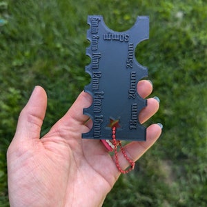 Peut inclure: Outil porte-cl&eacute;s en plastique noir avec une &eacute;toile et une cha&icirc;ne rouge. L'outil comporte des mesures en millim&egrave;tres de 5 mm &agrave; 30 mm.
