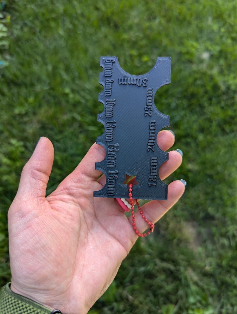 Peut inclure: Outil porte-cl&eacute;s en plastique noir avec une &eacute;toile et une cha&icirc;ne rouge. L'outil comporte des mesures en millim&egrave;tres de 5 mm &agrave; 30 mm.