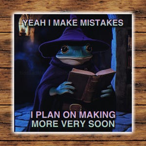 May include: A blue frog wearing a purple wizard hat and robe holds an old book. The text on the image reads "Yeah I make mistakes I plan on making more very soon."