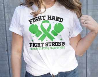 Puede incluir: Camiseta blanca con guantes de boxeo verdes y una cinta verde. El texto en la camiseta dice "Fight Hard Fight Strong Cerebral Palsy Awareness."