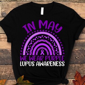 May include: Black t-shirt with a purple rainbow and hearts, and the text "In May We Wear Purple Lupus Awareness".